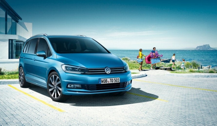 VOLKSWAGEN TOURAN stojící zaparkovaný u domu