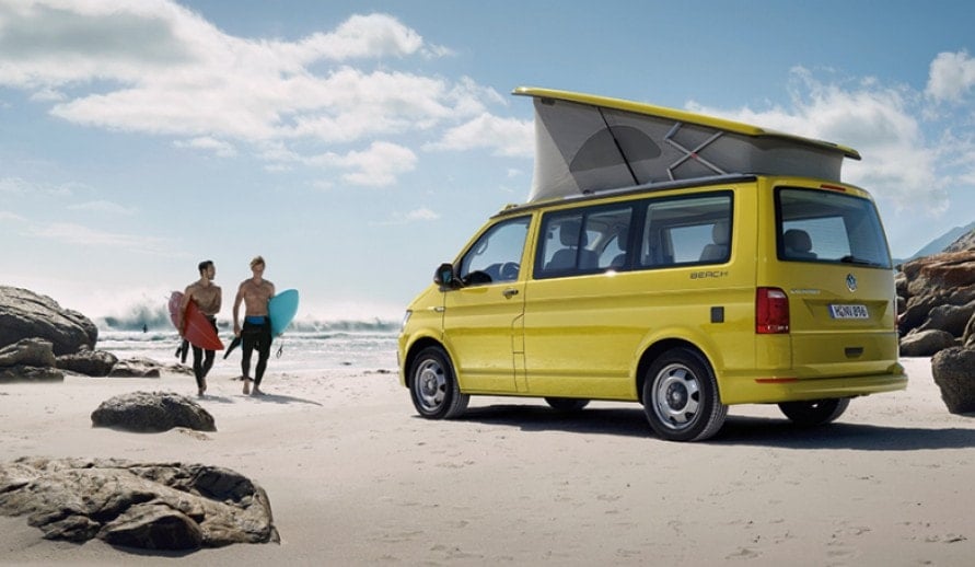 VOLKSWAGEN CALIFORNIA BEACH stojící na pláži s rozloženou střechou na spaní