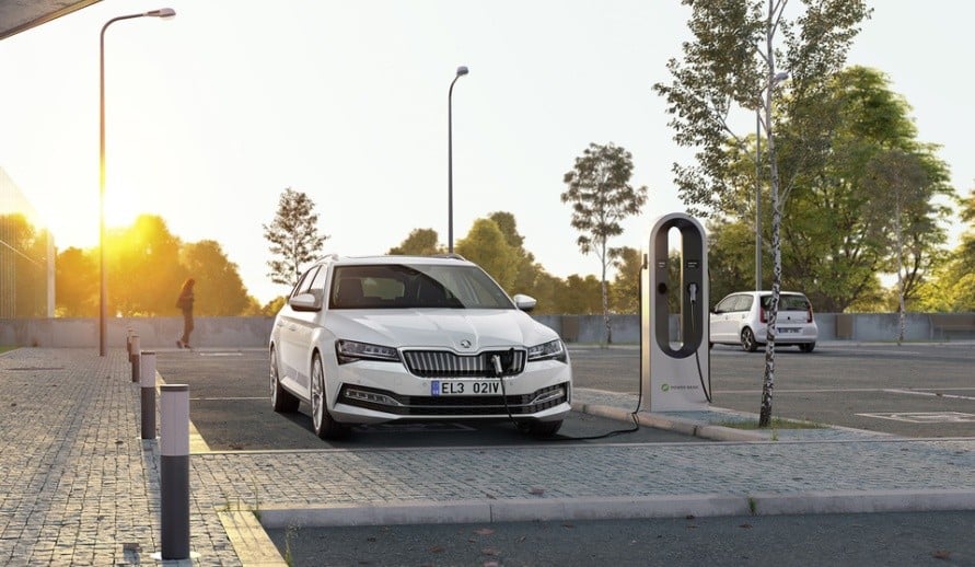 Škoda Superb iV zaparkovaný na parkovacím místě pro elektrické vozy připojený na nabíjecí sloupek