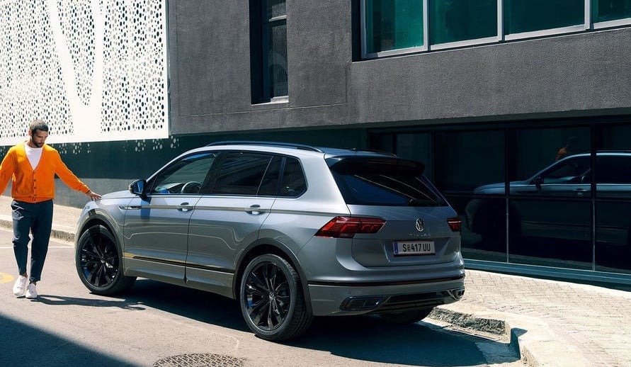 VOLKSWAGEN TIGUAN boční a zadní pohled na vůz stojící před budovou