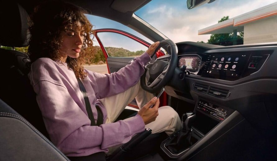 VOLKSWAGEN TAIGO žena propojuje mobilní telefon s vozem