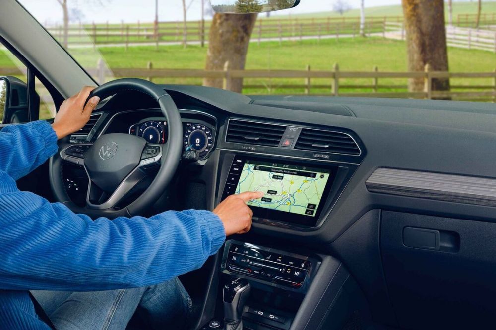 Řidič při nastavení autorádia a navigace ve voze Volkswagen Tiguan Allspace