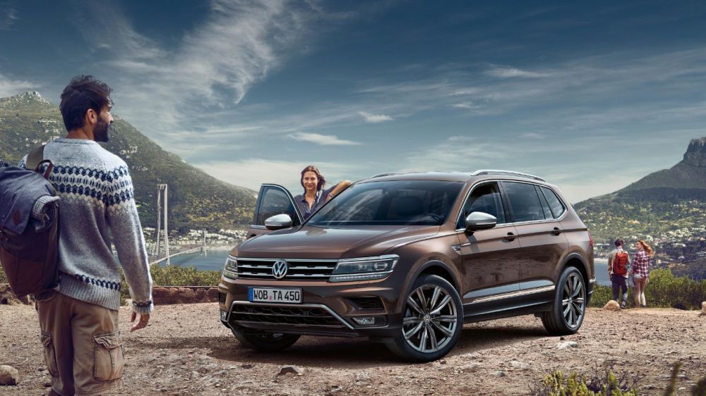 Volkswagen Tiguan Allspace v hnědé barvě stojící na horské vyhlídce